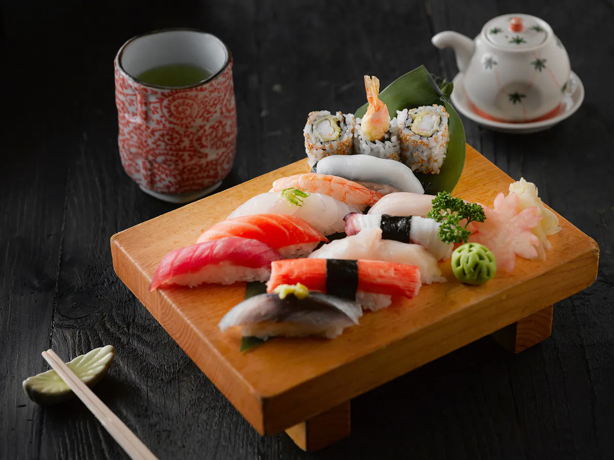 Assorted nigiri sushi platter with green tea and teapot